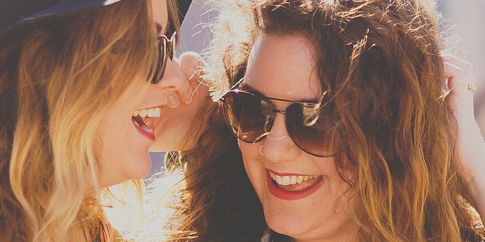 Two women laughing together outdoors