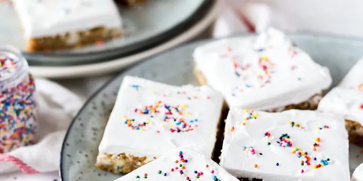 盘子里铺满糖霜生日蛋糕方块和彩色糖珠